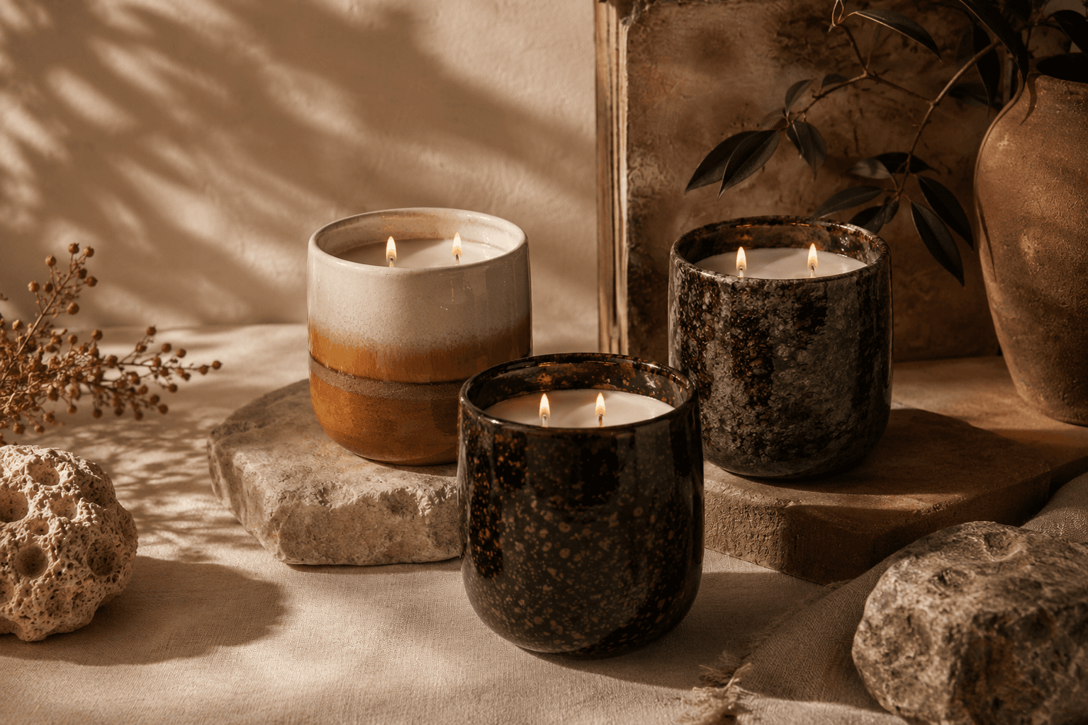 Three Sensora First Edition candles in glazed clay vessels